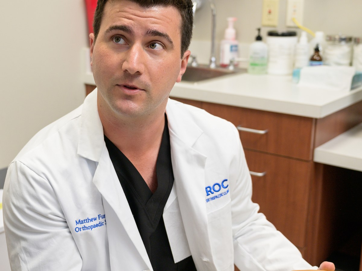 Dr. Matt Fury talking through a knee model in clinic at Baton Rouge Orthopaedic Clinic