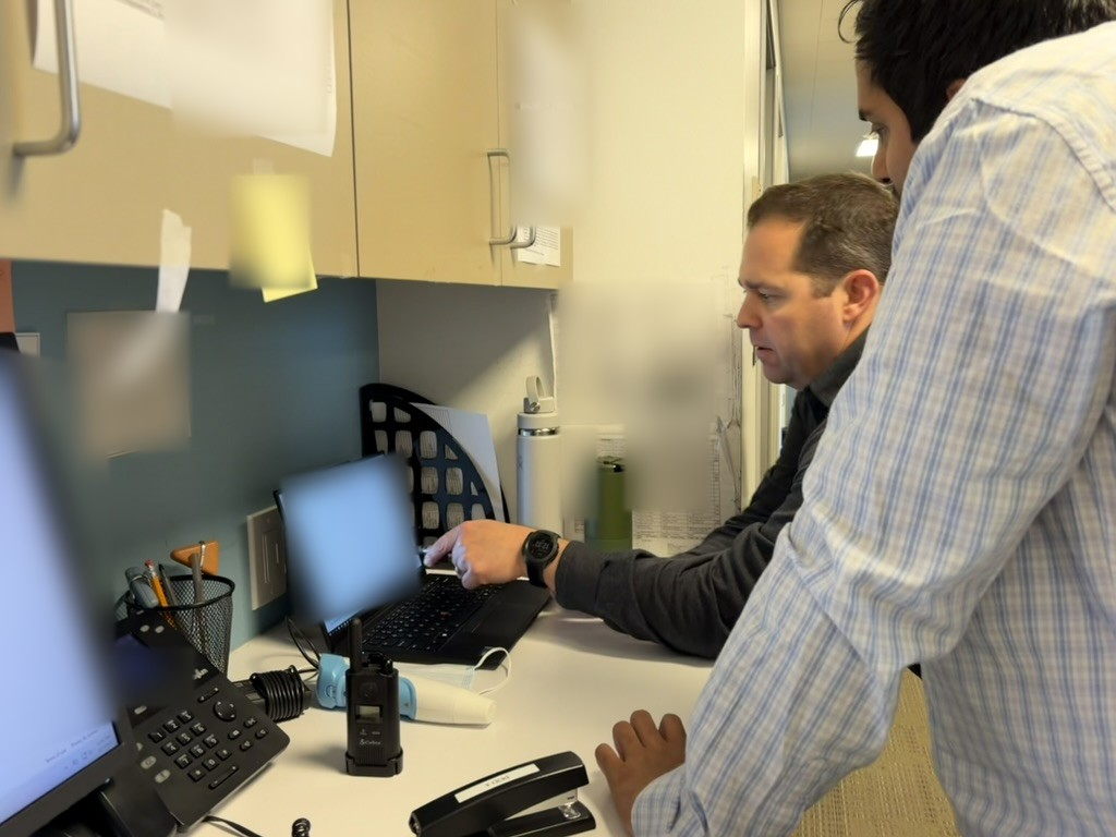 Dr. Rivadeneyra and Pavan reviewing a note in Mira at the Orange office